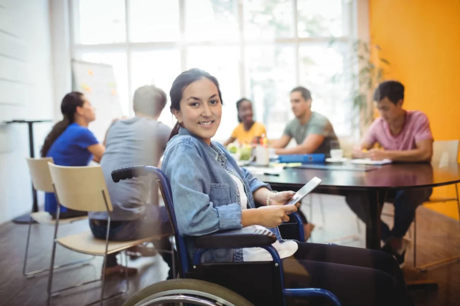 Executive with a disability using a digital tablet while smiling at the camera