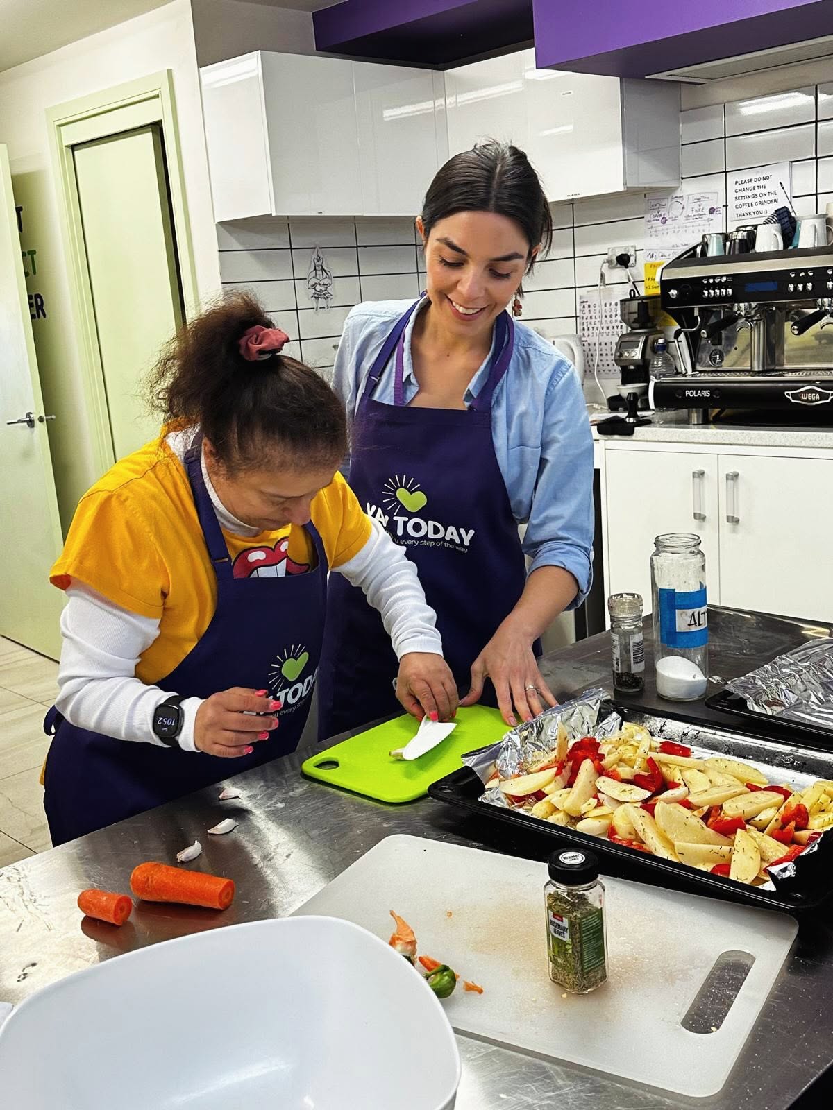 A support worker helping a participant in the kitchen at YAY Today